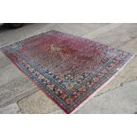 A Persian carpet of Herati design on a pink ground with blue floral borders, 128" x 82" approx