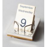 A silver faced desk calendar