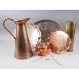 A hammered copper jug with tapering sides, a brass shell case, an oval copper kettle, a copper