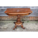 A carved rosewood shaped fold-over top tea table, on turned column and circular base with scroll