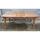 A late Victorian oak dining table, fitted one extra leaf, on turned and reeded supports, 67" x 40"