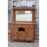 An Arts & Crafts oak dresser with raised mirror back, flanked by embossed copper panels over two