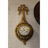 A French gilt and black metal wall clock with ribbon finial, white enamel dial, Roman and Arabic