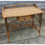 A rattan ledge back side table, fitted one drawer, on splay supports, 40" wide x 23" deep x 34" high