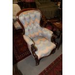 A Victorian mahogany showframe armchair with scroll arms, upholstered in a Florentine fabric, on