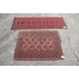 A Bokhara rug with ten central medallions, geometric designs and multi-borders on a faded red