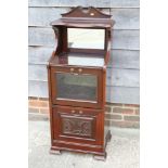 A late 19th century walnut music cabinet with ledge back over fall front glass door and drop front