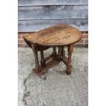An oak oval drop leaf low occasional table, on gate leg support, 21" wide x 26" deep x 19" high