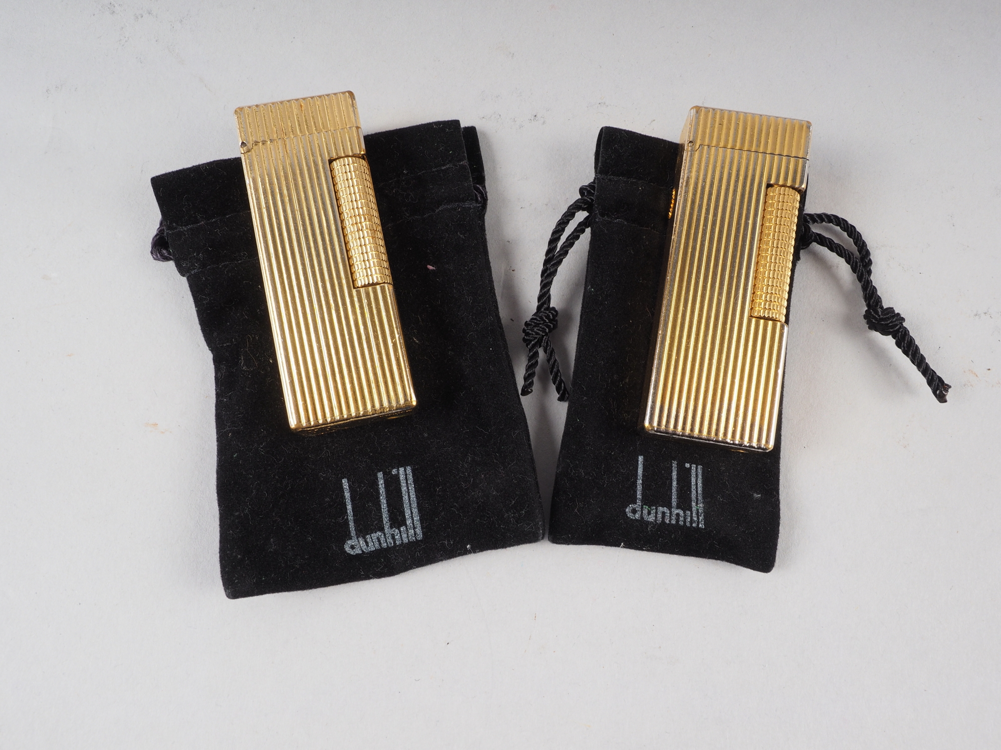 Two gold plated Dunhill butane cigarette lighters with original velvet pouches