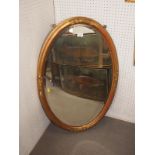 An oval bevelled edge wall mirror, in gilt frame, plate 32" x 20"