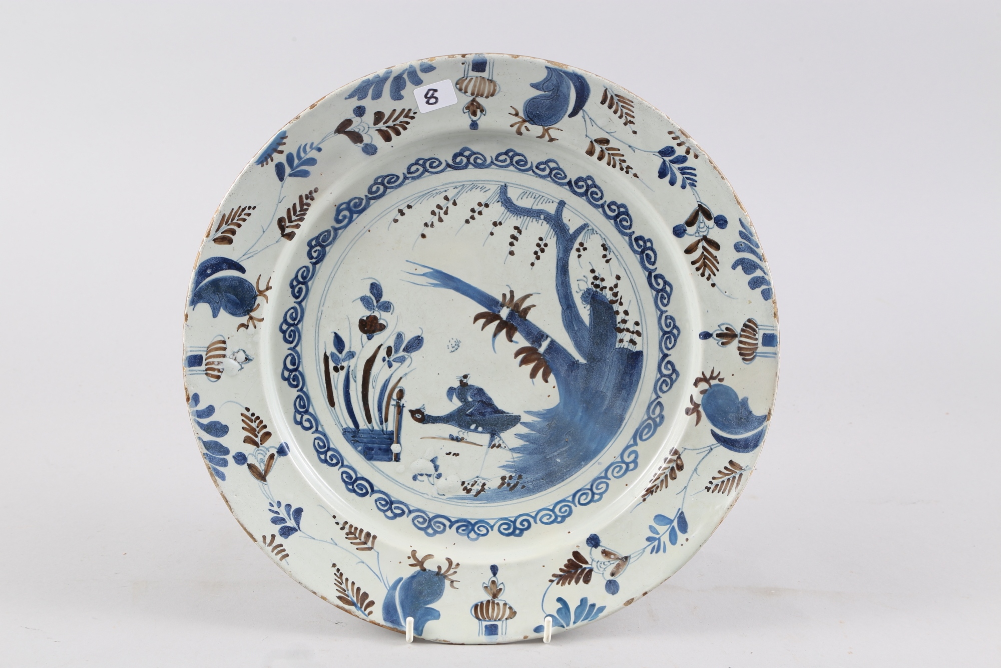An early 18th century Bristol blue and manganese charger with bird and fence design, 13 1/2" dia,