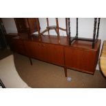 An A H McIntosh & Co teak sideboard with three cupboards and three short drawers, on taper supports,