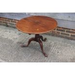 A Georgian mahogany circular tilt top coffee table, on turned column and tripod splayed supports, 29