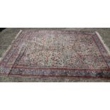 A Persian part silk pile rug with an all-over scroll floral design in shades of blue, red, green and