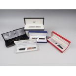 Two black Montblanc black biros, in presentation cases, and three other boxed fountain pens, by