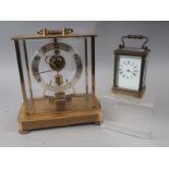 A Kundo battery operated mantel clock and a brass carriage clock (glass side panel broken)