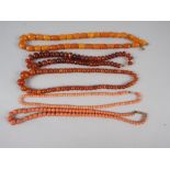 A pale butterscotch amber bead necklace, 18" long, 25.7g, two translucent amber necklaces and two
