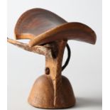 An Ethiopian Bashada carved hardwood neck rest, on shaped base, 6 1/2" high