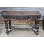 A 19th century Continental carved oak side table, fitted three drawers, on turned supports united by