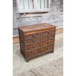 An 18th century oak panel front chest of four drawers with split turnings and knob handles, on bun