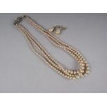 A faux pearl three-strand necklace and a pair of faux pearl drop earrings