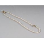 A single row of cultured pearls (ninety approx 4-4.5mm dia) with a single pearl and diamond set gold