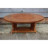 A 1960s oval teak low coffee table, on elephant supports, 42" wide x 25" deep x 18" high
