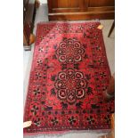 A Persian tribal rug with two star medallions on a red ground, 29 1/2" x 47 1/2" approx