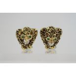 A pair of yellow metal earrings, formed as crouching leopards, set emeralds, diamonds and black
