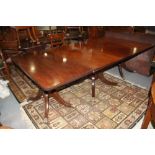 A 19th century mahogany triple pedestal dining table with two extra leaves, on turned columns and