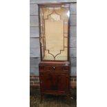 An Edwardian mahogany display cabinet, the upper section enclosed glazed panel door over one