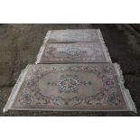 A Chinese contour pile rug with floral design on a grey ground, 70" x 36" approx, and a pair of