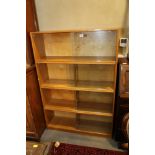 A light oak sectional bookcase enclosed four pairs of sliding glass doors, on block base, 36" wide x