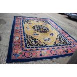 A Chinese contour pile carpet of traditional design with sacred objects on an old gold ground,