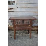 A Chinese carved elm side table, fitted two drawers, on turned supports, 39" wide x 19" deep x 32