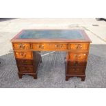 A mahogany double pedestal desk with green leather tooled lined top, fitted nine drawers, on bracket