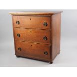 A child's late 19th century oak chest of three long drawers with brass ring handles, on bun feet, 19