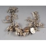 A silver charm bracelet with twenty-one charms approx, 3.4oz troy approx