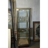 A brass glazed cabinet with two glass shelves, 17 1/2" square x 55" high