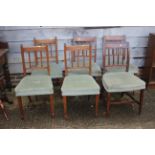 A matched set of six vertical rail back dining chairs with stuffed over seats, on square taper