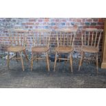 A set of four circular panel seat and stick back kitchen chairs, on turned and stretchered supports