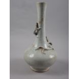 A Chinese bottle necked vase with pale glaze and relief dragon decoration, 13" high (restored)