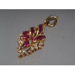A Thai yellow metal scrollwork pendant, stamped 750, set rubies and diamonds, 4.3g gross