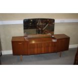 An Avalon Yatton teak dressing chest with mirrored back and two central long drawers, flanked by