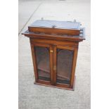 A 19th century walnut hanging cabinet enclosed two arch top glazed panel doors with secret