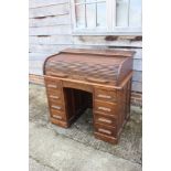 A 19th century oak roll top desk with fitted interior over nine drawers with slides, block base, 42"