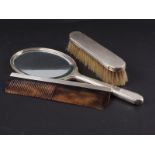 An engine turned silver backed toilet mirror, and a companion brush and comb