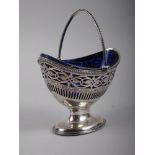 A Georgian silver oval swing handled pedestal sweet meat basket with pierced and engraved