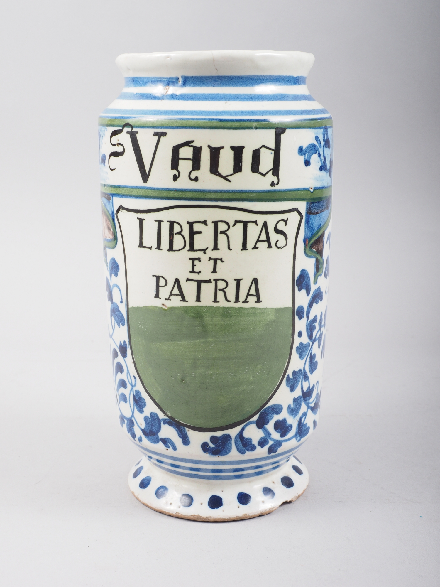 A majolica albarello inscribed "St Vaud" and "Libertas et Patria", 3 1/2" high (rim chip)