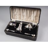 A silver three-piece cruet set, in fitted case, 12.5oz troy approx (one glass liner missing)